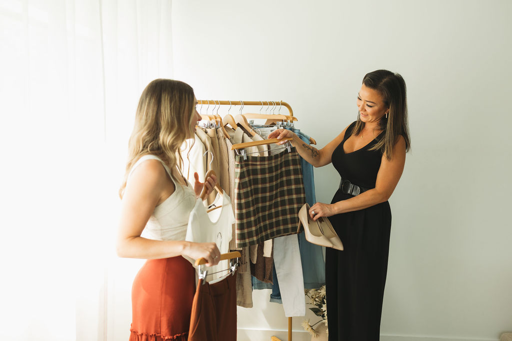 Two women styling outfits from the Sip. Style. Shoot. clothing rack during a content day.